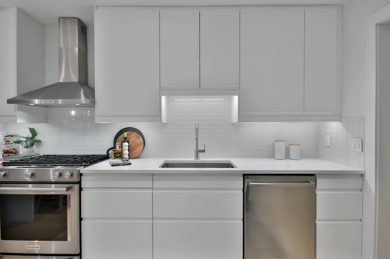 Kitchen with white shaker cabinets, stainless appliances and subway tile