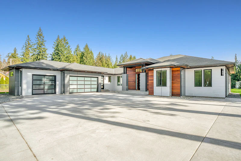 Single-level modern ranch home with wood accents and a wide driveway